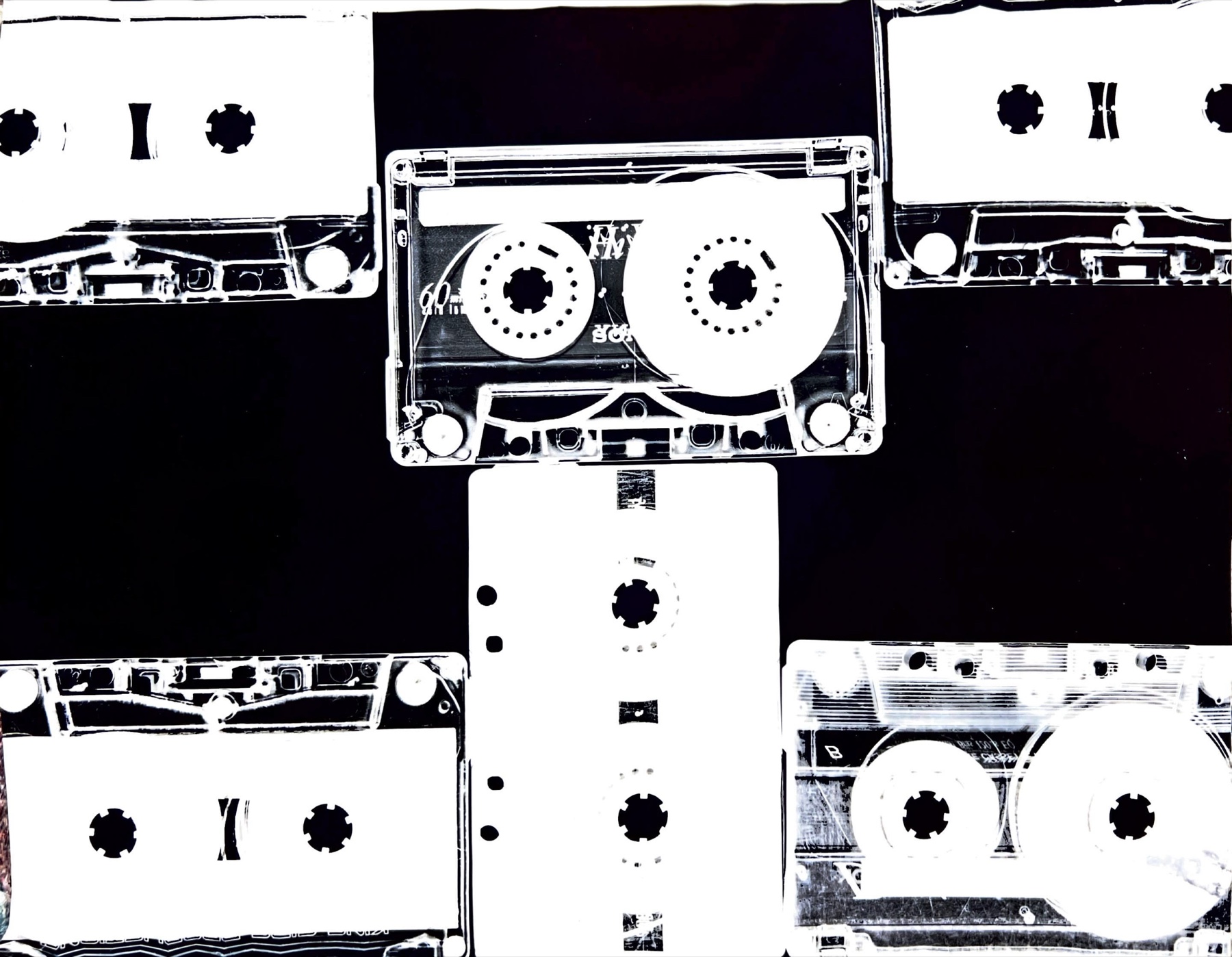 A high-contrast photogram composed from overlapping cassette tapes