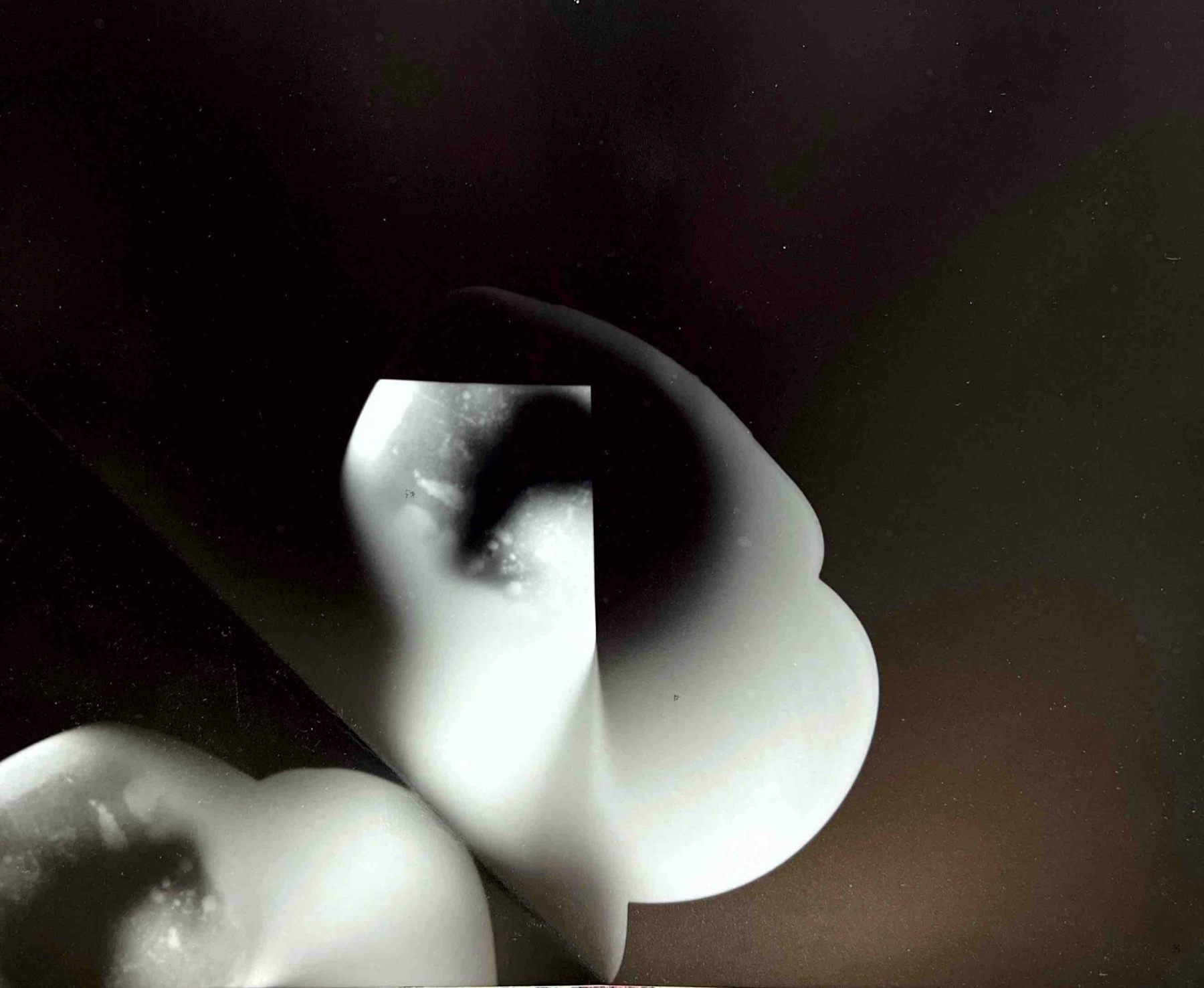 A dark photogram of layered folded paper forms
